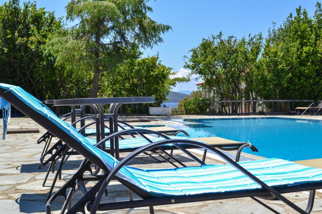 a group of lounge chairs next to a swimming pool at Villa Alba Chiara in Ouranoupoli