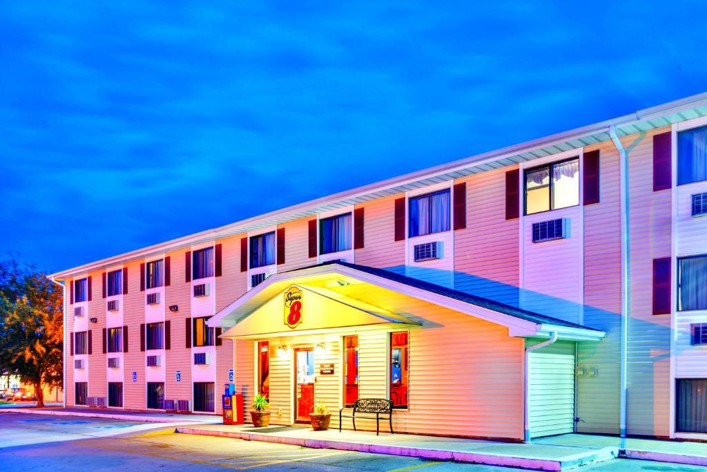 a pink and white building with a building at Super 8 by Wyndham Burlington in Burlington