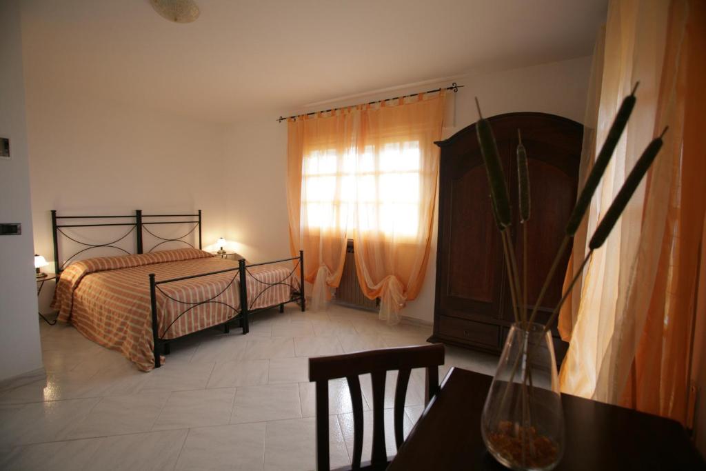 a bedroom with a bed and a table and a window at Bed And Breakfast casagalez in Santa Domenica