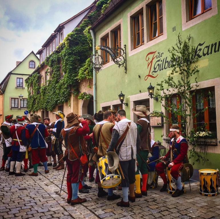 un gruppo di persone che si trovano fuori da un edificio di Ferienwohnungen Monteurzimmer zur Silbernen Kanne a Rothenburg ob der Tauber