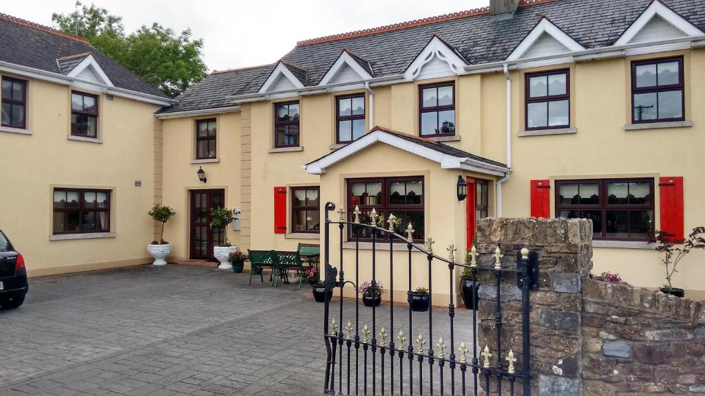 ein großes Haus mit einem Zaun davor in der Unterkunft Grannagh Castle House in Waterford