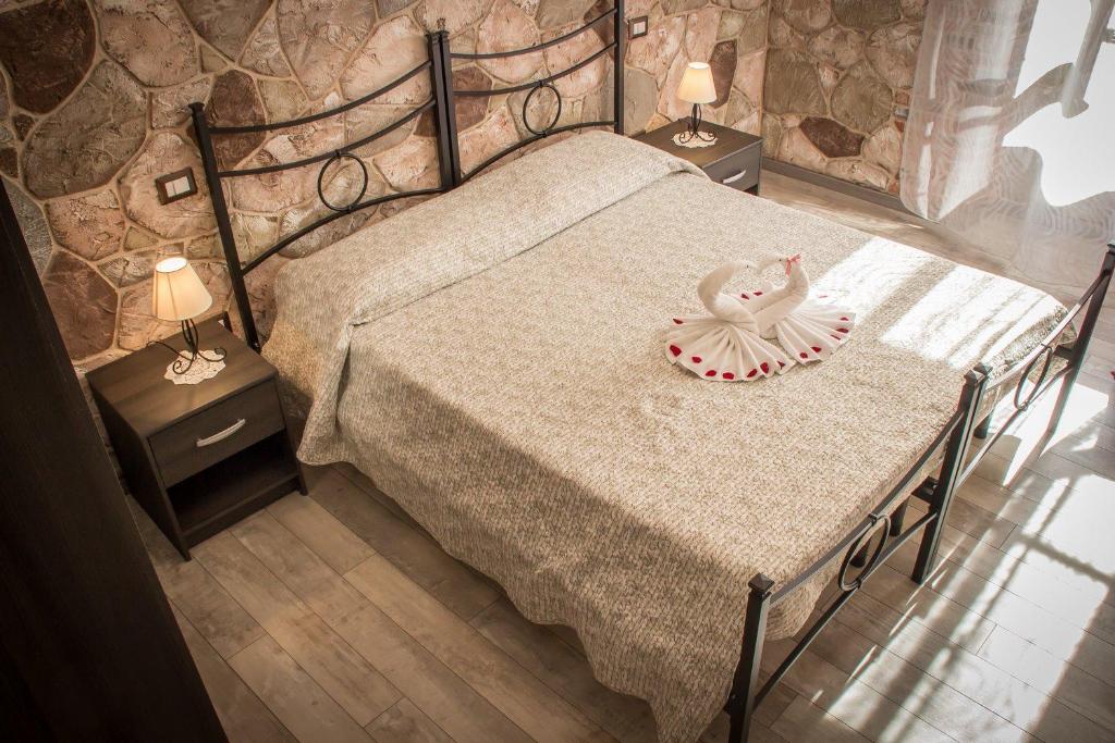 ein Schlafzimmer mit einem Bett und zwei Nachttischen mit Lampen in der Unterkunft Rocca Pinta Guest House in Alghero