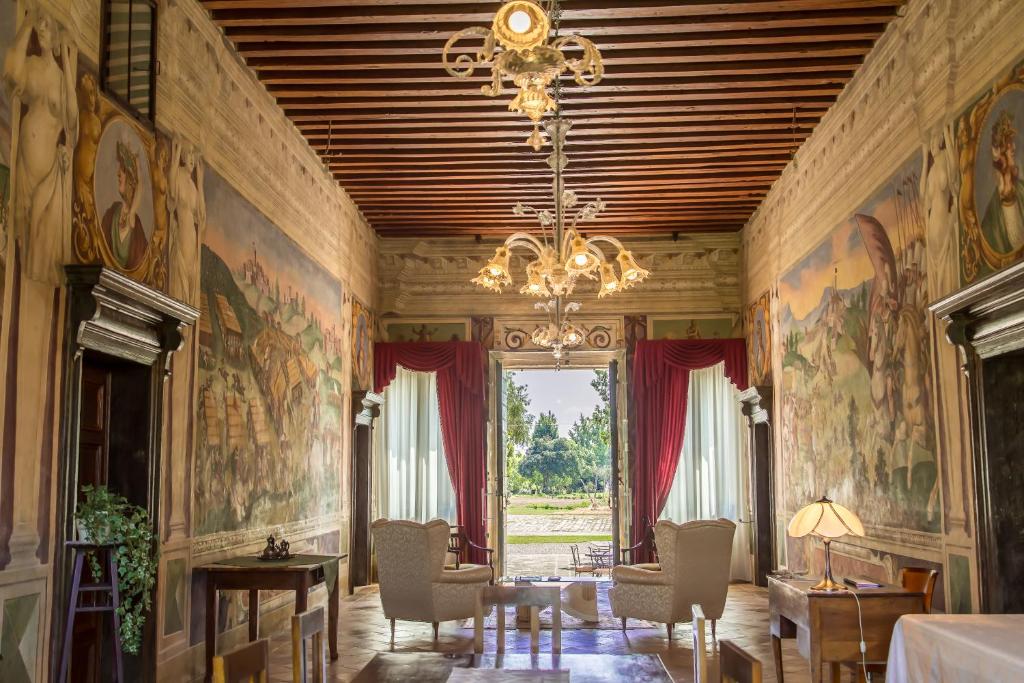 um quarto com pinturas nas paredes e um lustre em Azienda Agricola Marin em Este