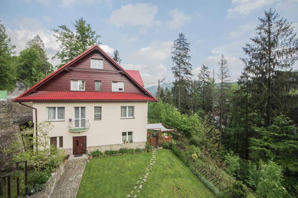 una casa con techo rojo y patio en Villa Kokosowa, en Wisła