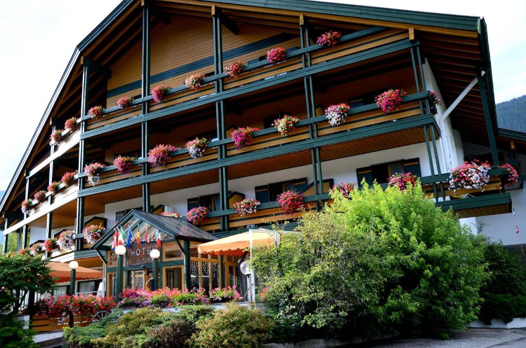 ein Gebäude mit Blumen auf den Balkonen in der Unterkunft Hotel Brandl in Innichen