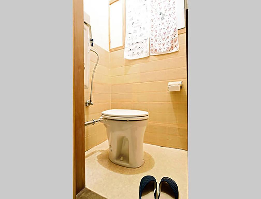 a bathroom with a toilet and a pair of shoes at City Hotel Universal Studios Japan in Osaka