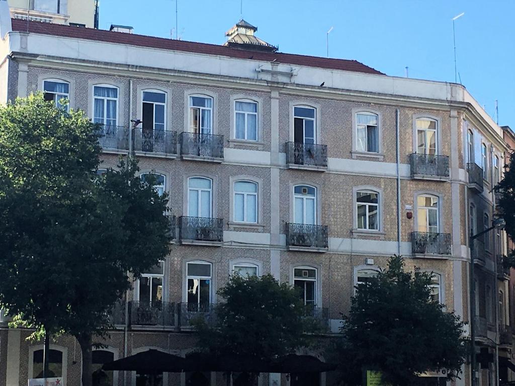リスボンにあるレジデンシア ホワイトラブの大きなレンガ造りの建物で、窓とバルコニーが付いています。