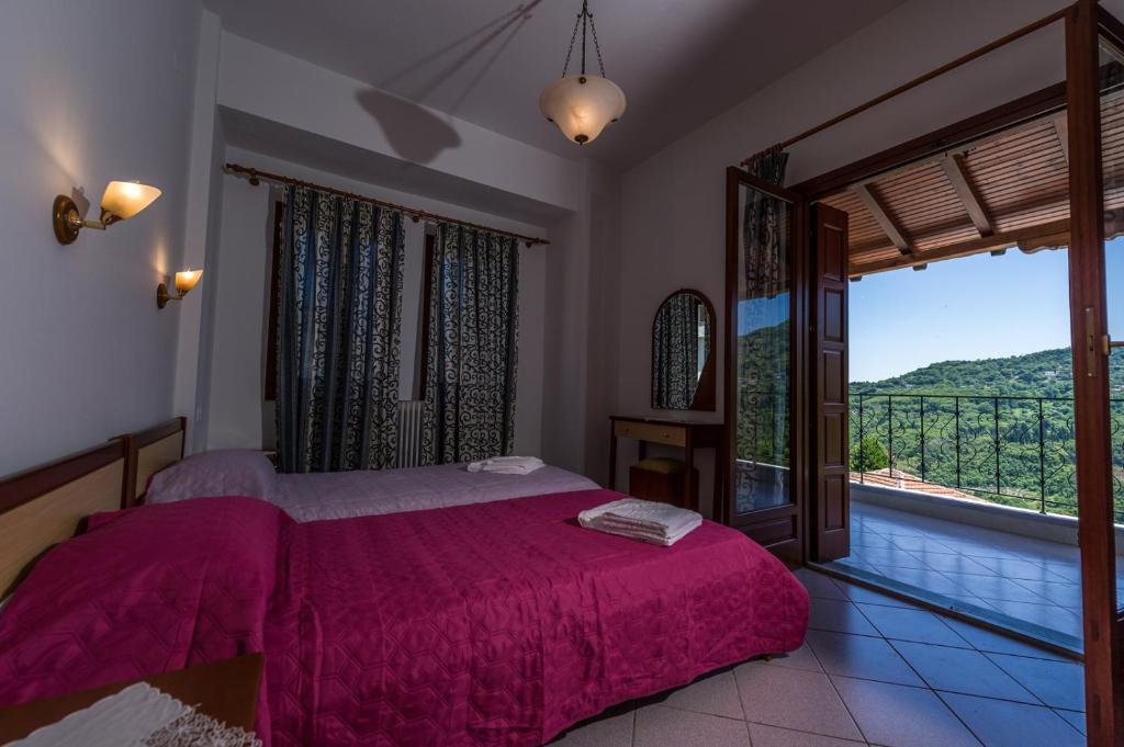 een slaapkamer met een bed en een groot raam bij House of Gardenia in Makrirrákhi