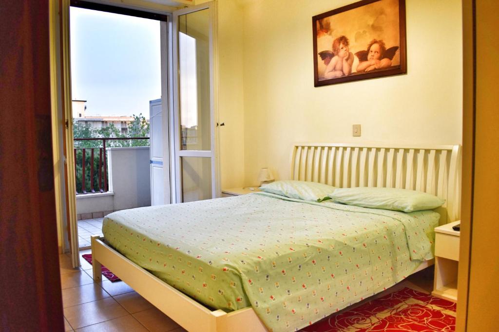 チェゼナーティコにあるBilocale Valverdeのベッドルーム1室(ベッド1台付)が備わります。バルコニーの景色を望めます。