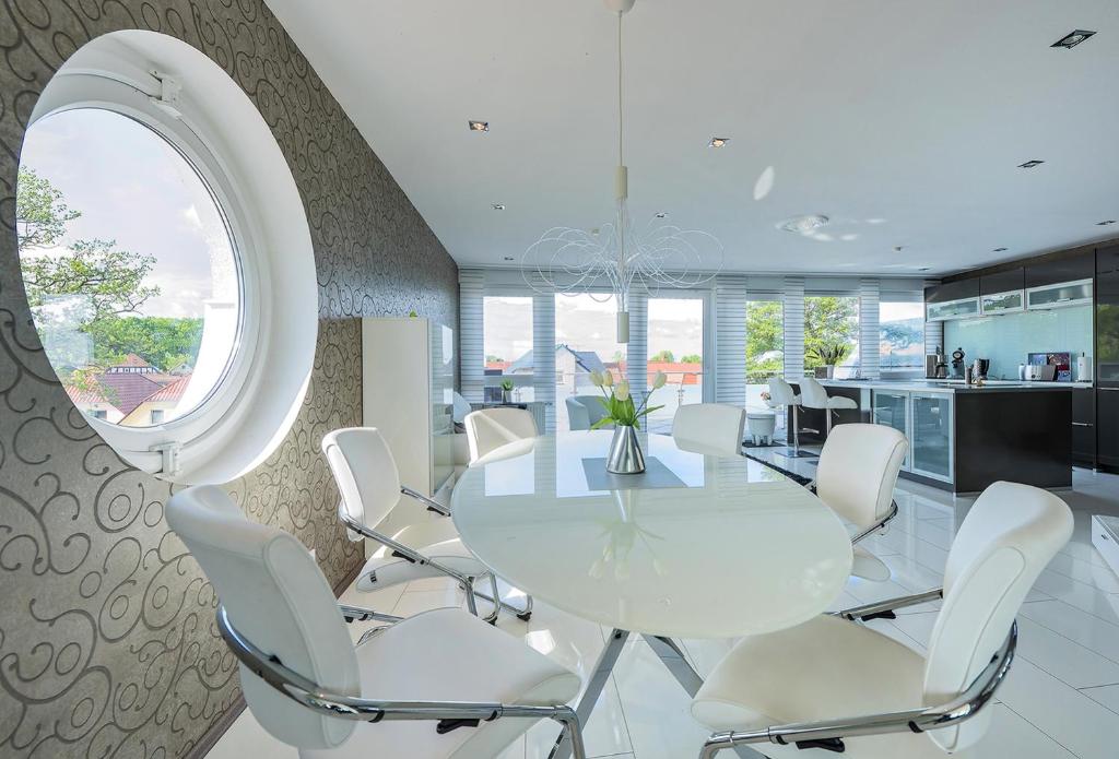 een eetkamer met een witte tafel en witte stoelen bij Steinhuder Meer Am Leuchtturm in Wunstorf