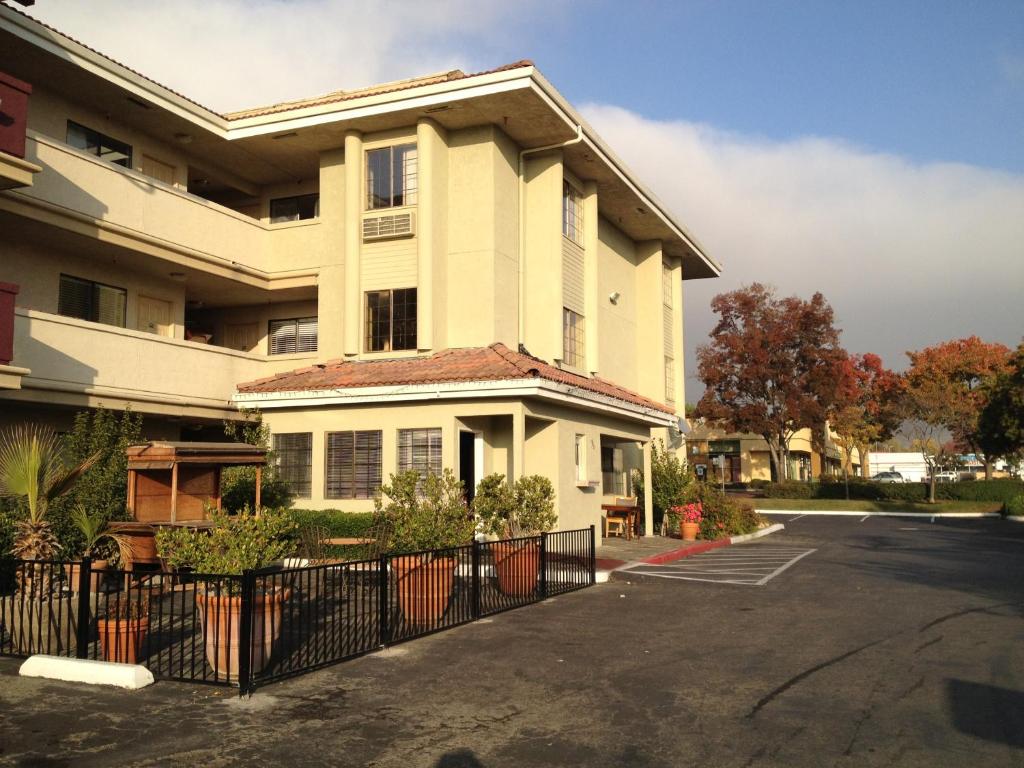 a white building with a fence in front of it at Executive Inn in Milpitas