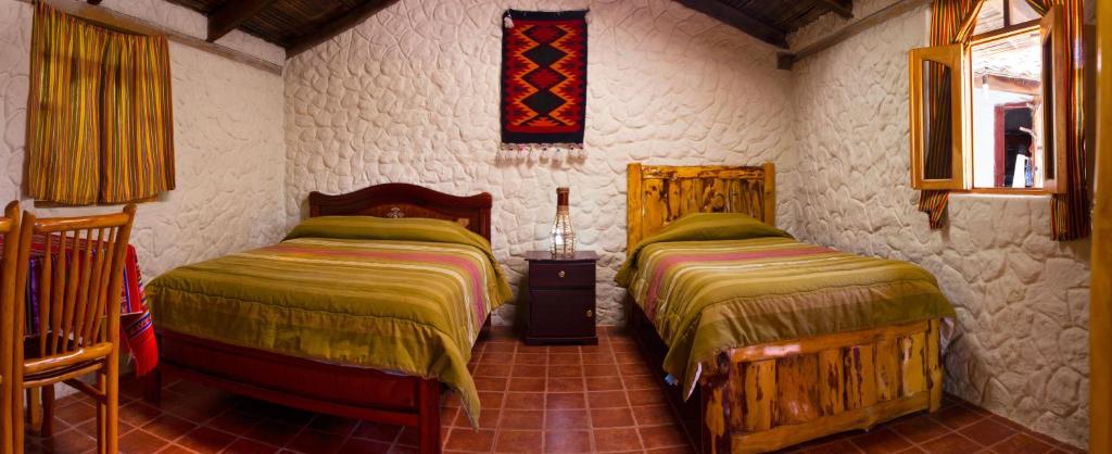 a bedroom with two beds in a room at Kallpa Wasi in Cotacachi
