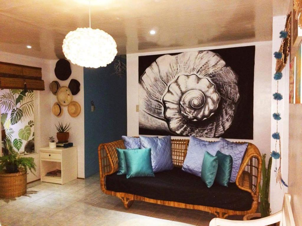 un sofá en una sala de estar con una pintura en la pared en My Hostel Boracay, en Boracay