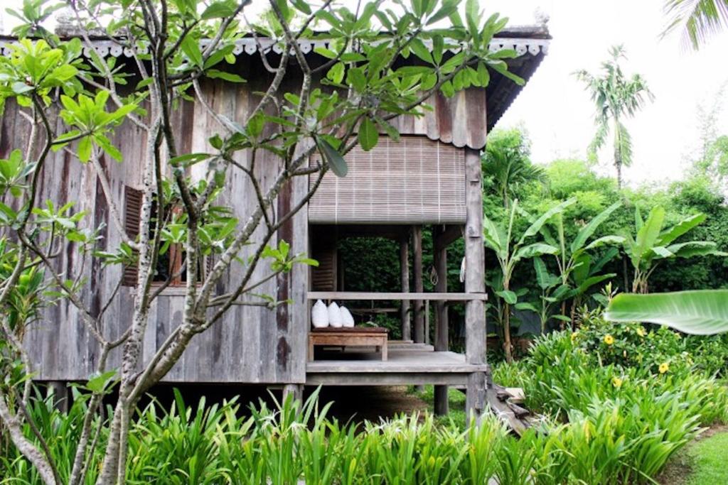 a small building with a bench in a garden at Sala Lodges in Siem Reap