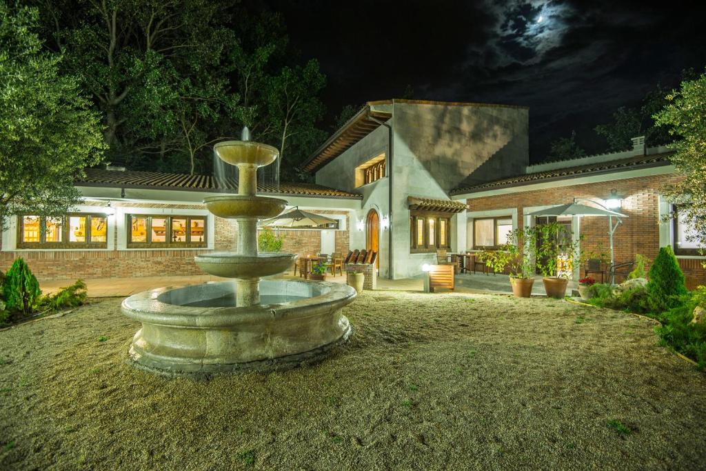 una fontana di fronte a una casa di notte di Finca Valdobar a Peñafiel