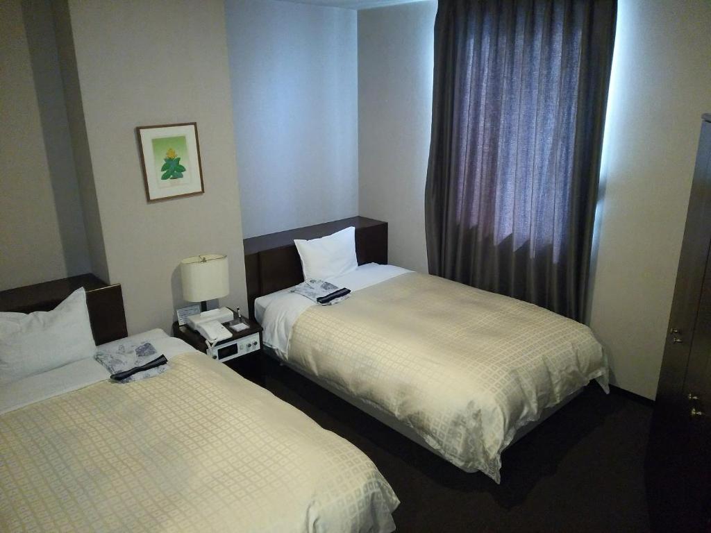 Ένα ή περισσότερα κρεβάτια σε δωμάτιο στο Hirosaki Grand Hotel