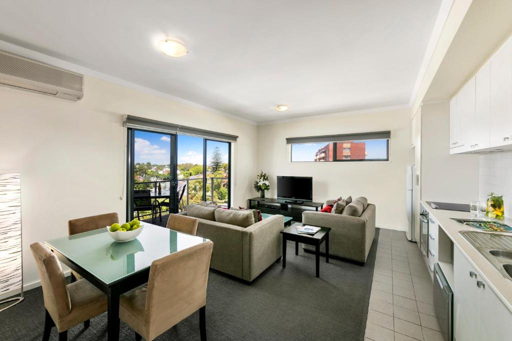 cocina y sala de estar con sofá y mesa en Quest on Rheola, en Perth