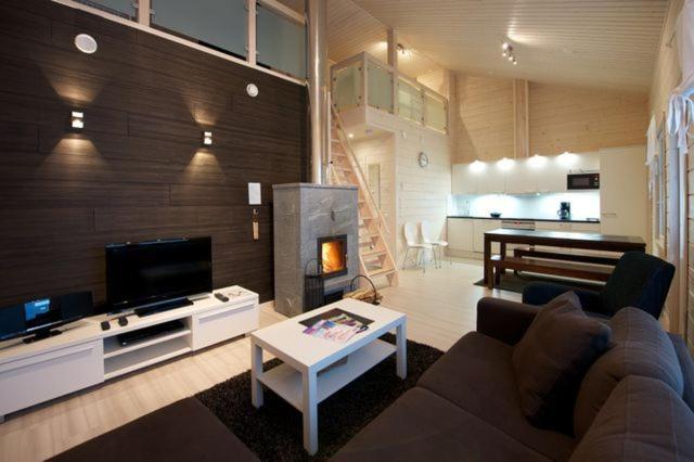 a living room with a couch and a fireplace at Rukankarhu Apartment II in Ruka