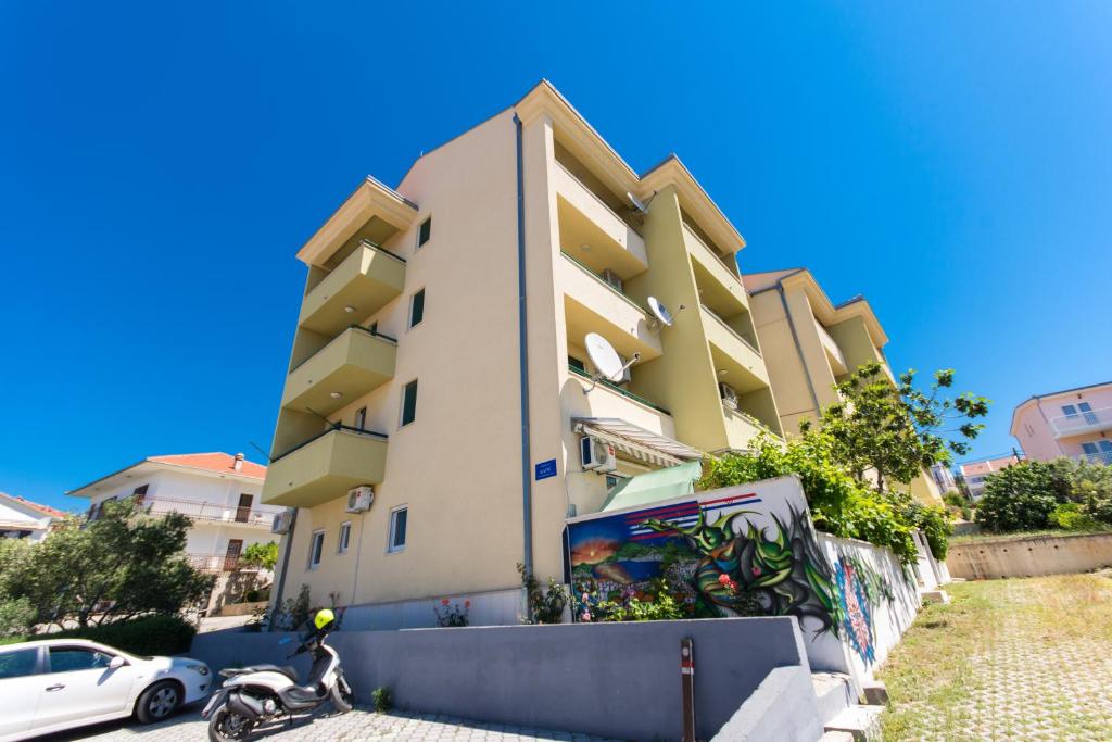 a building with a motorcycle parked in front of it at Apartments Katic in Trogir