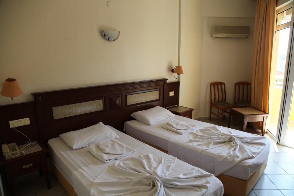 A bed or beds in a room at Alin Hotel