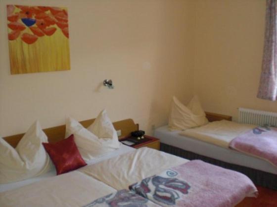 Habitación con 2 camas y una pintura en la pared. en Hotel Bergkristall, en Schwarzenberg am Bohmerwald
