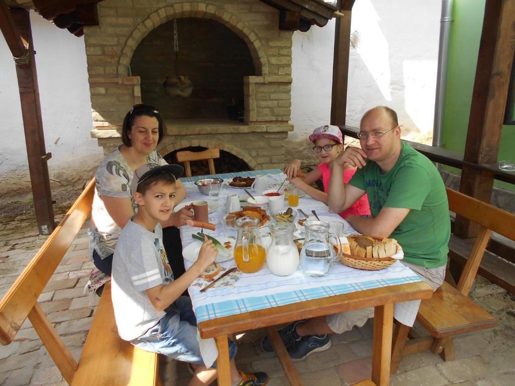 a group of people sitting at a table eating food at Guest House Stara Baranja in Kneževi Vinogradi