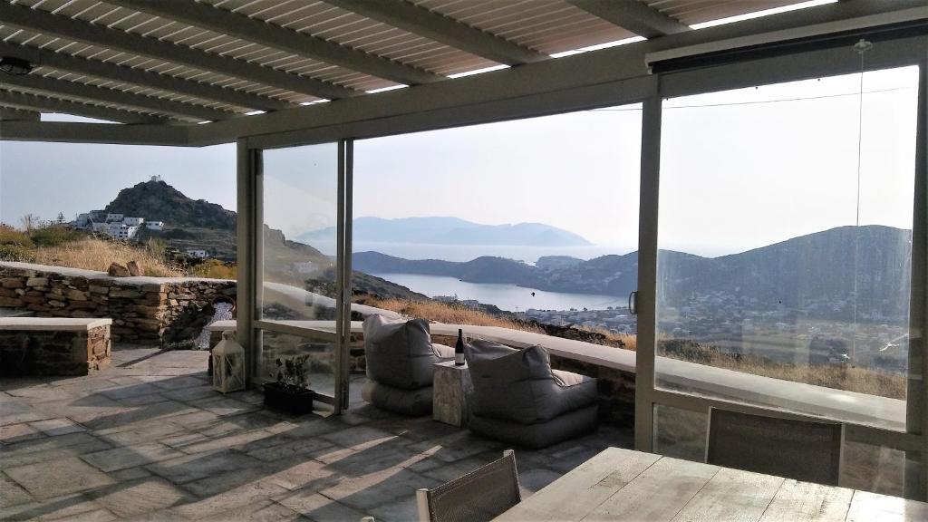 a balcony with a view of the water and mountains at Villa Baya in Ios Chora