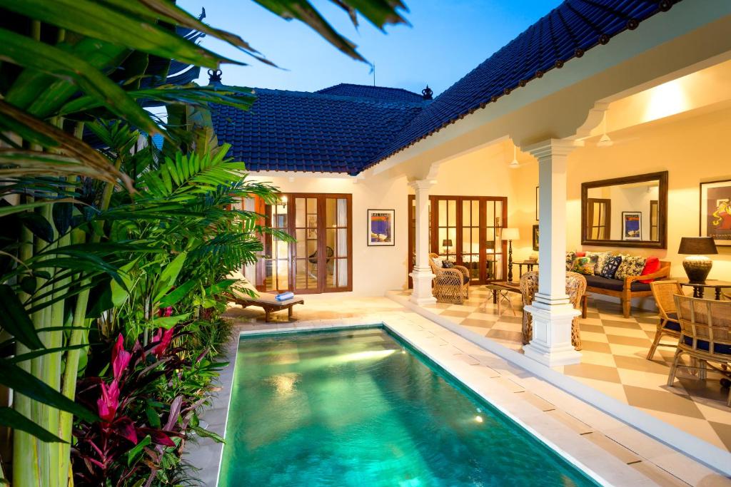 a villa with a swimming pool and a living room at Villa Antiga 2 in Seminyak