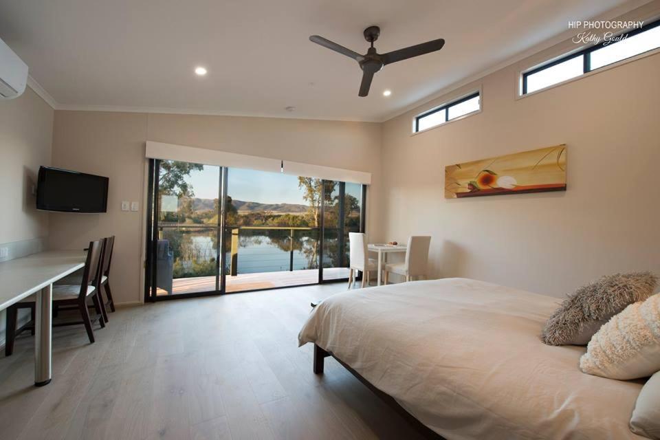 ein Schlafzimmer mit einem Bett, einem Tisch und einem Schreibtisch in der Unterkunft Still Earth in Port Pirie