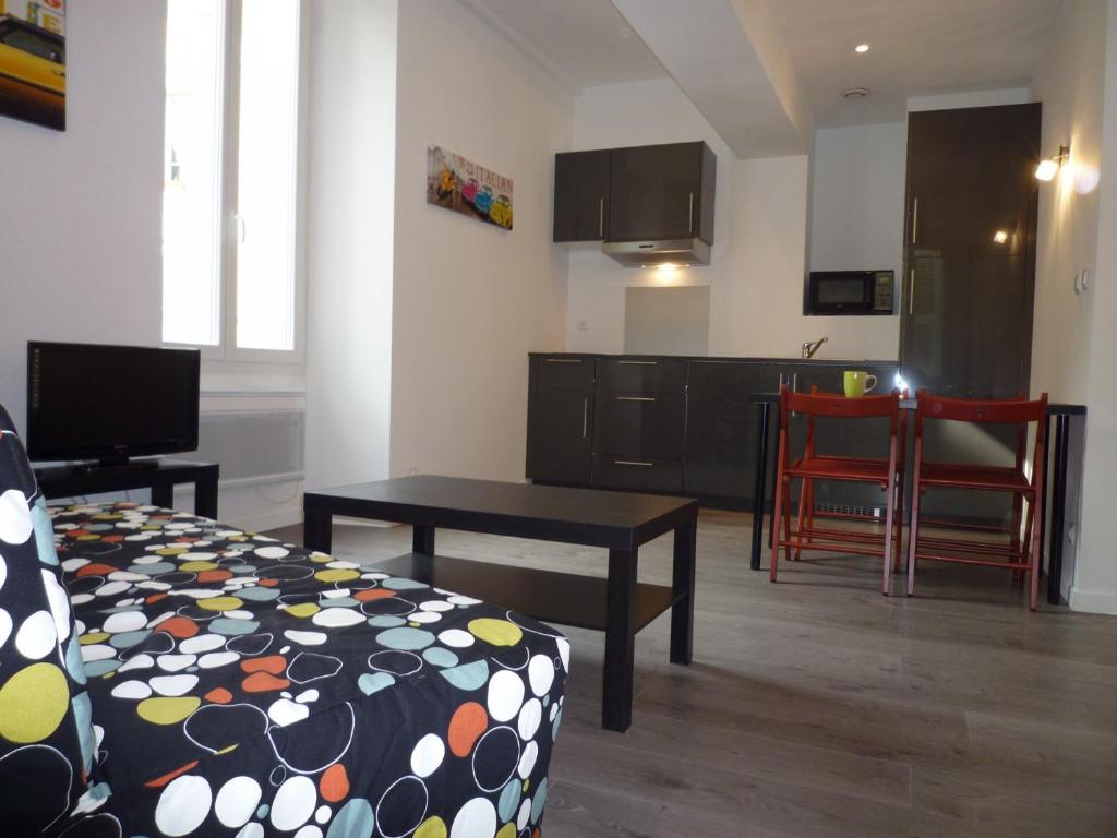 un salon avec un canapé et une table et une cuisine dans l'établissement La Loge, à Nice