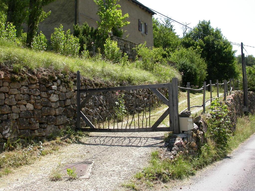 une porte en bois sur un mur en pierre à côté d'une route dans l'établissement Sabatou, le cottage Cévenol, à Florac Trois Riviere