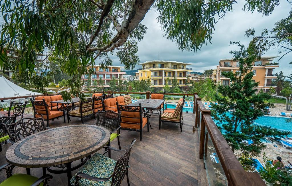 an outdoor patio with tables and chairs and a pool at Dream Land Oasis in Chakvi