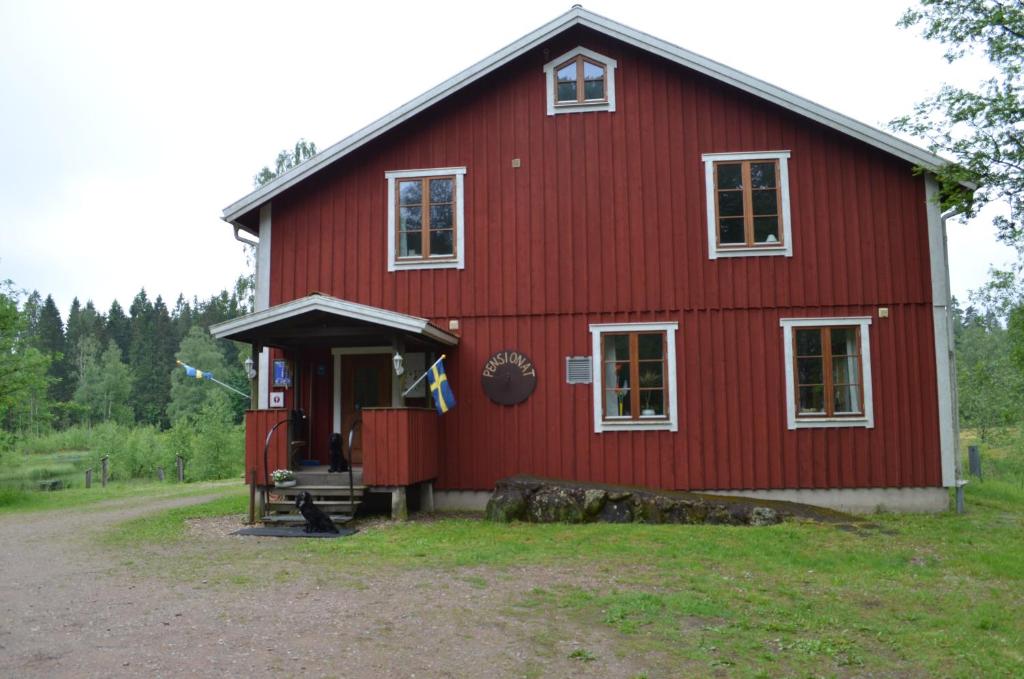 a red barn with the door open in a field at Pensionat Sågknorren in Bygget