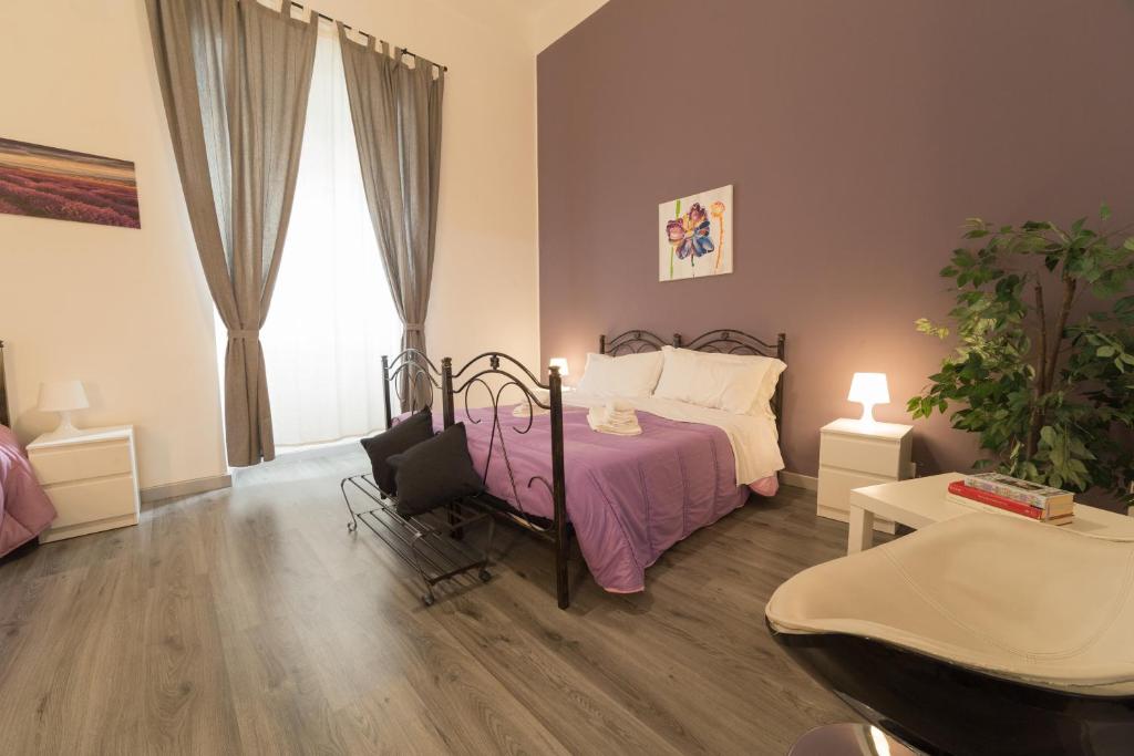 a bedroom with a bed and a table and a window at Tra L'Etna E Il Mare B&B in Catania