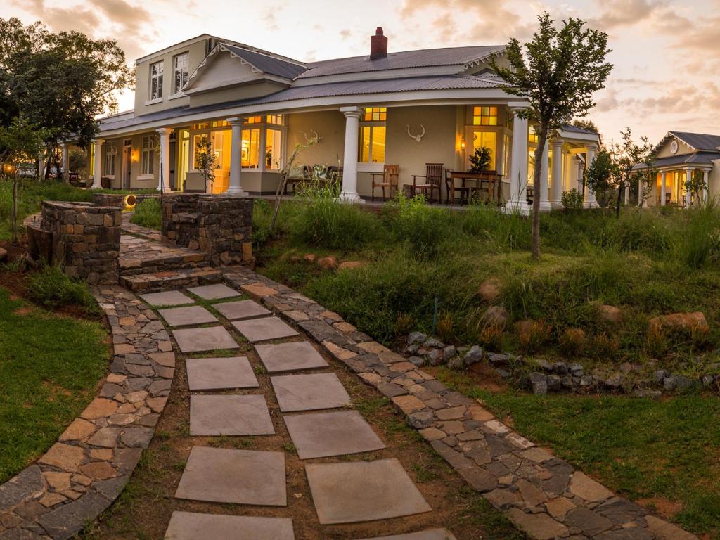 una casa con una pasarela de piedra delante de ella en The Royal Fischer Hotel en Bloemfontein