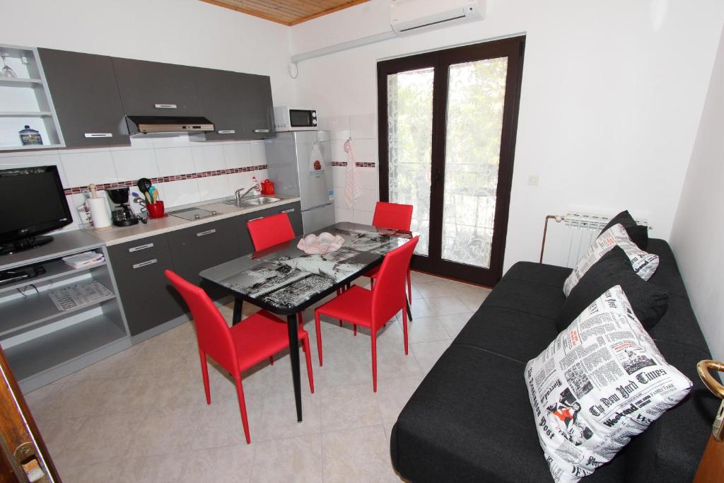 kuchnia ze stołem i czerwonymi krzesłami w pokoju w obiekcie Apartments Marlina w Rovinj