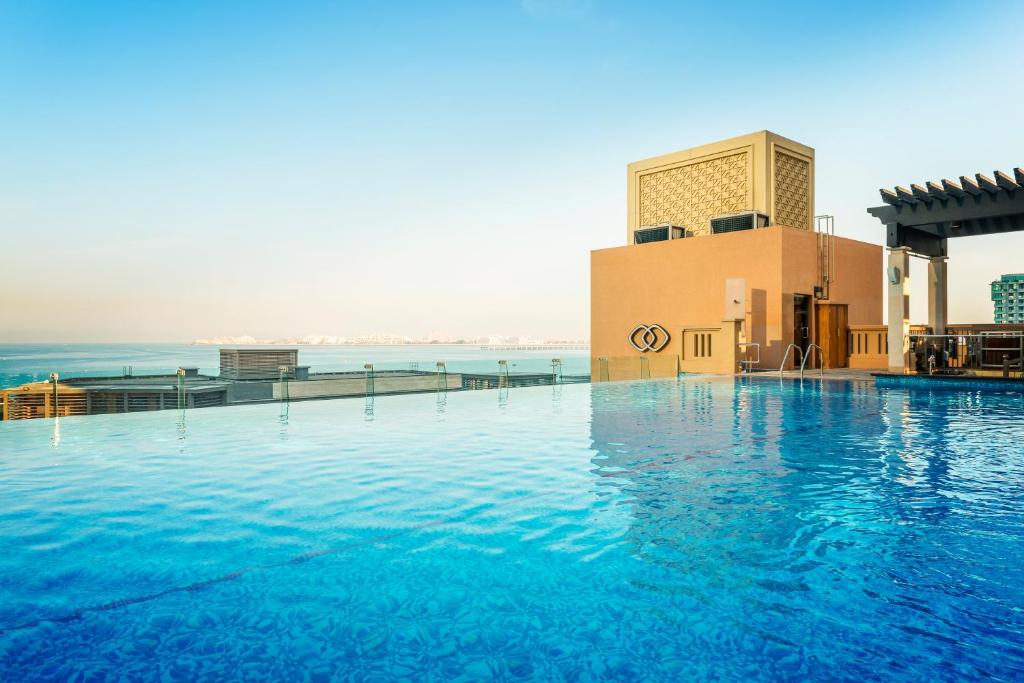 a large swimming pool in the middle of a beach at Sofitel Dubai Jumeirah Beach in Dubai