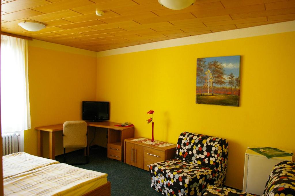 a bedroom with a bed and a desk and a chair at Pension Duel in Ústí nad Labem