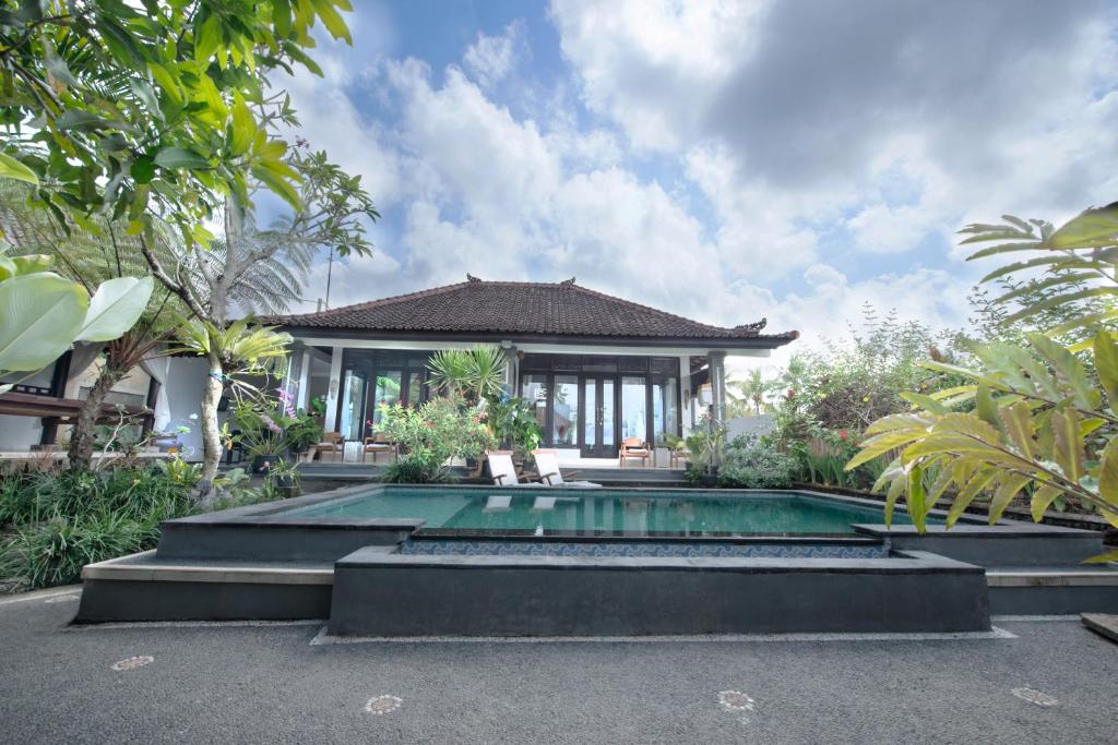 a swimming pool in front of a villa at Pondok Anastasia in Ubud