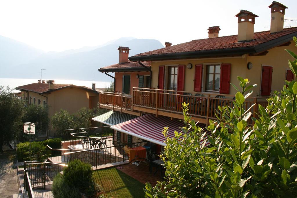 a house with a balcony with a mountain in the background at Residenza Cristina in Brenzone sul Garda