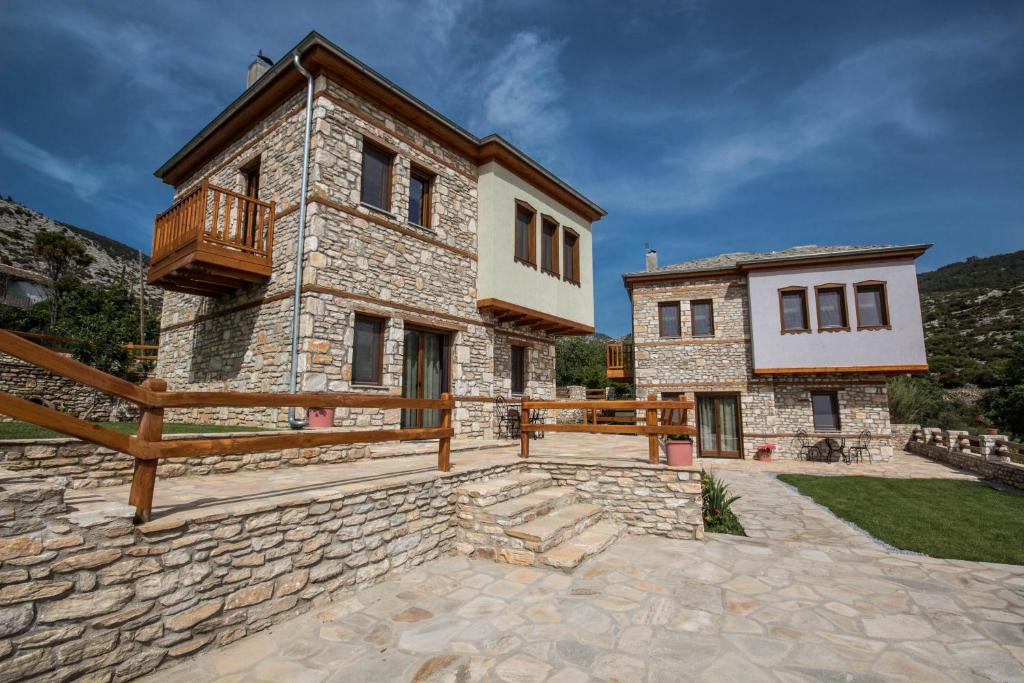 a large stone house with a balcony on the side of it at Harmony Deluxe Villas in Theologos