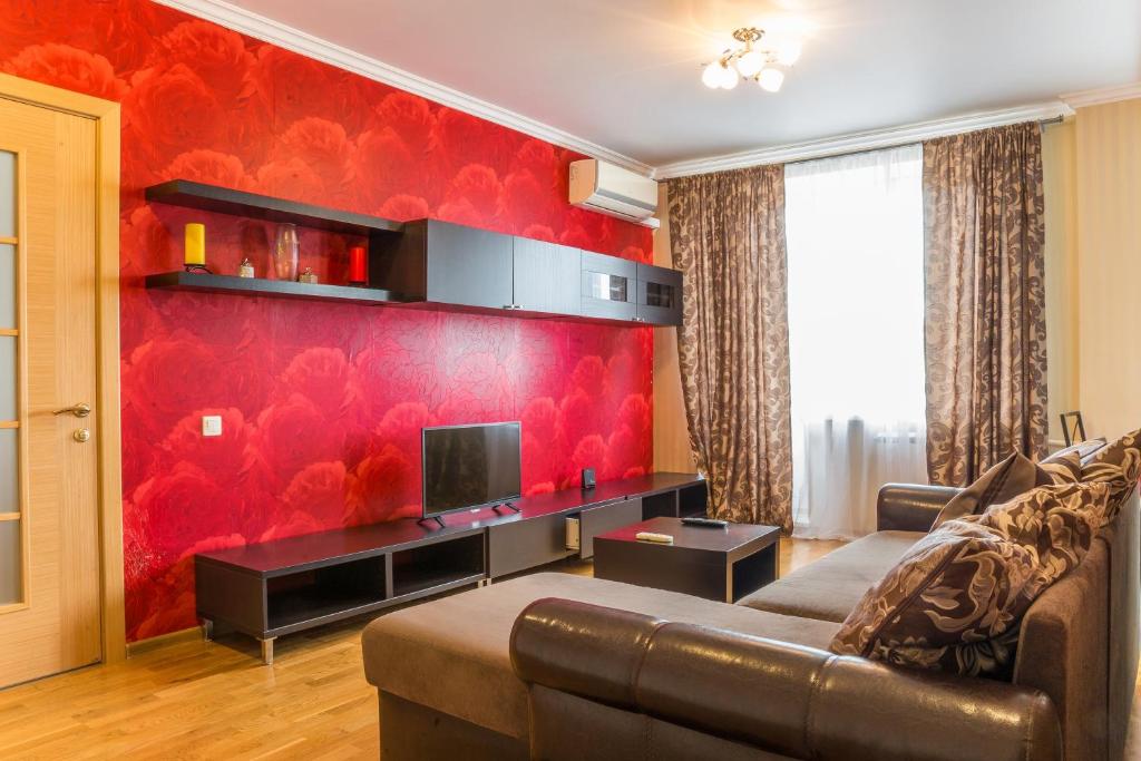 モスクワにあるДизайнерские Апартаменты на Фрунзенскойの赤い壁のリビングルーム(ソファ付)