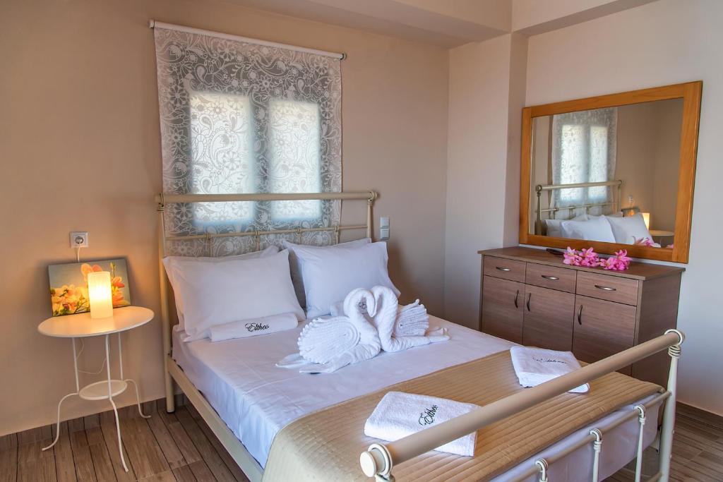 a bedroom with a bed with towels and a mirror at Eltheo Villas in Agios Nikitas