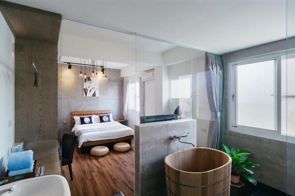 台南的住宿－慕特民宿，一间卧室配有一张床和一个水槽和一个浴缸
