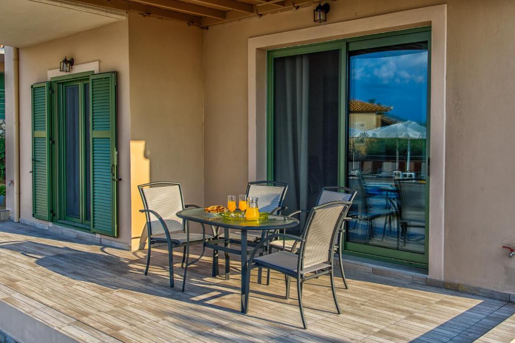 a table and chairs on a deck with a view of a patio at Eltheo Villas in Agios Nikitas