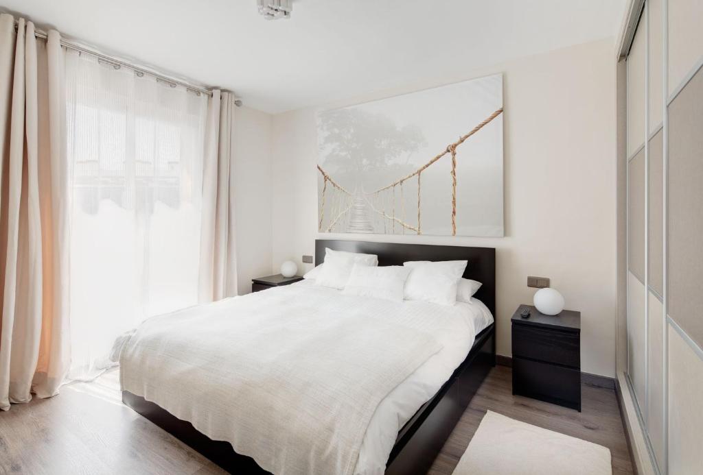 a white bedroom with a large bed and a window at Luxury Apartment In Marbella in Marbella