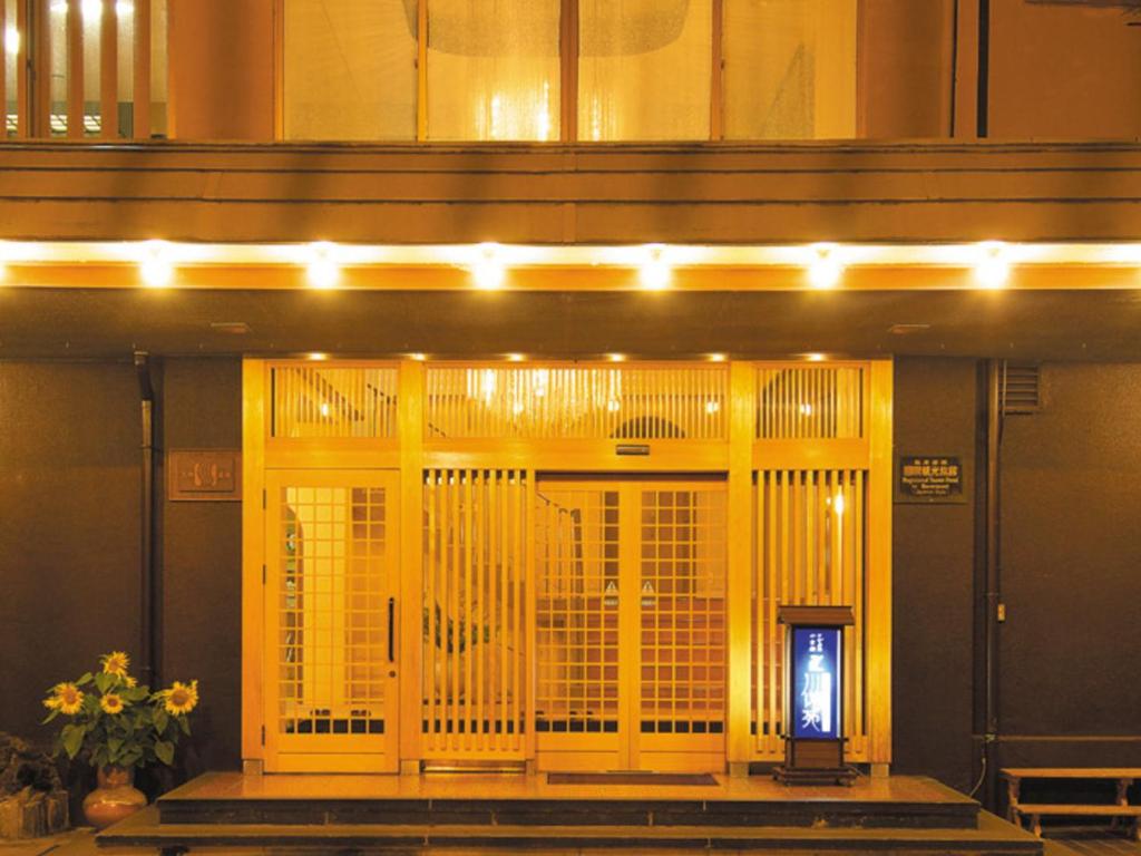 un edificio con una puerta amarilla con luces encendidas en Yugawara Onsen Kawasegien Isuzu Hotel, en Atami