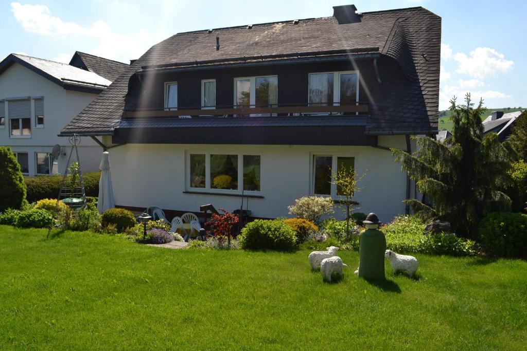 a house with sheep statues in the yard at Pension Robin Hood in Willingen