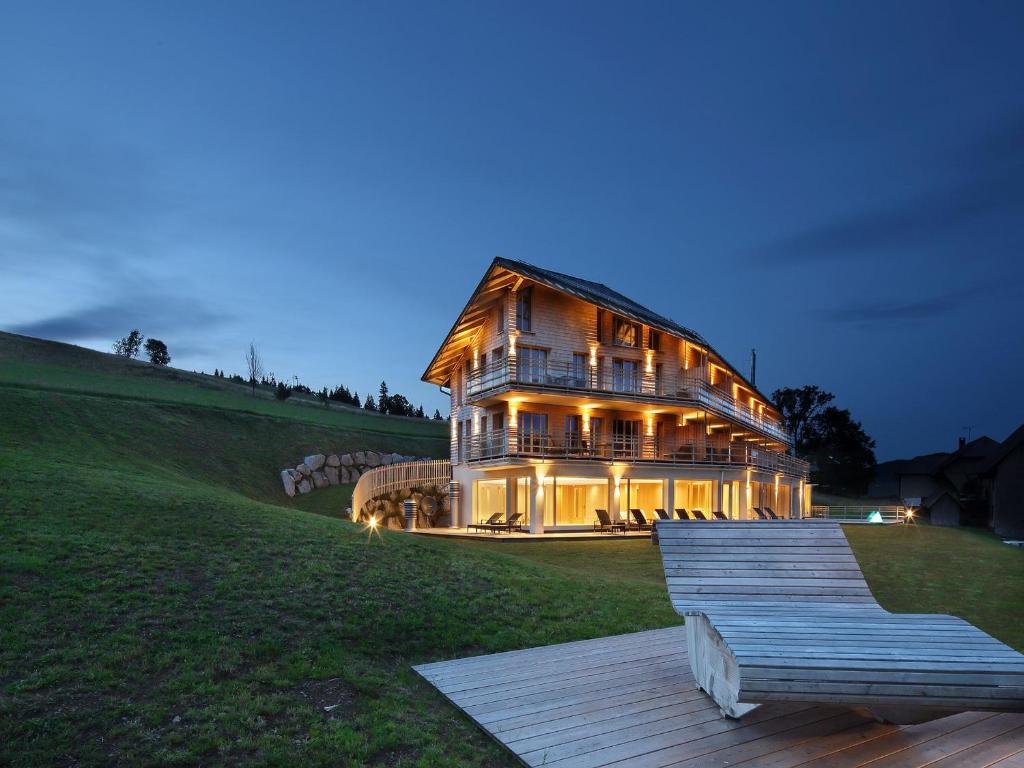 een groot huis op de top van een heuvel 's nachts bij derWaldfrieden naturparkhotel in Herrenschwand