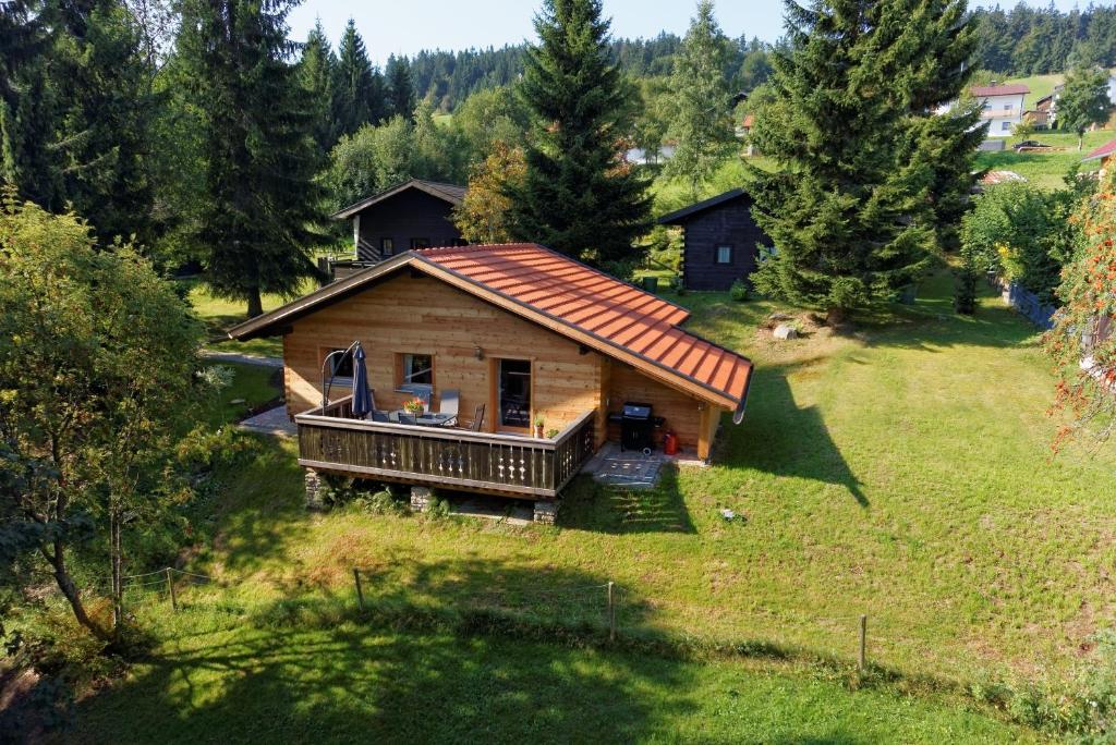 una pequeña casa de madera en un campo con árboles en Ferienhaus Mitterdorf, en Philippsreut